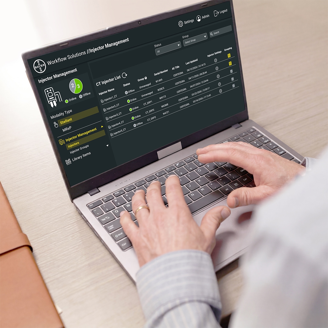 Radiology staff using a laptop to monitor injector management and device status information
